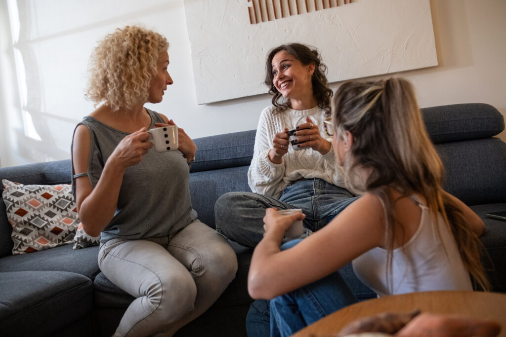 people sitting in a living room drinking coffee