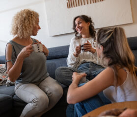people sitting in a living room drinking coffee