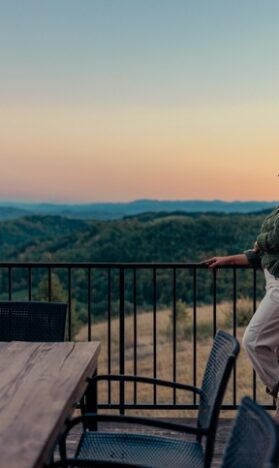 Photo of a retired couple enjoying their fall vacation with mountains in the background