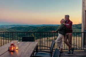 Photo of a retired couple enjoying their fall vacation with mountains in the background