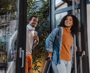 Two travelers smiling as they arrive at a vacation rental property — iTrip Vacation Rental Week social graphic